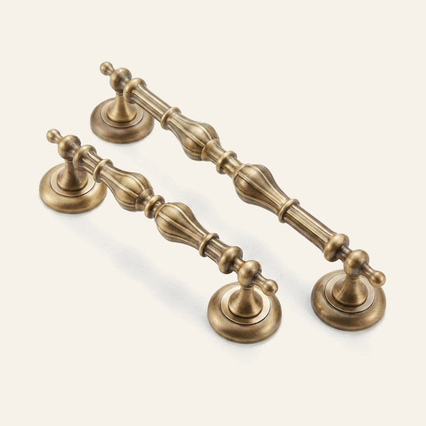 Castor solid brass cabinet pull with gourd-turned grip on bell roses