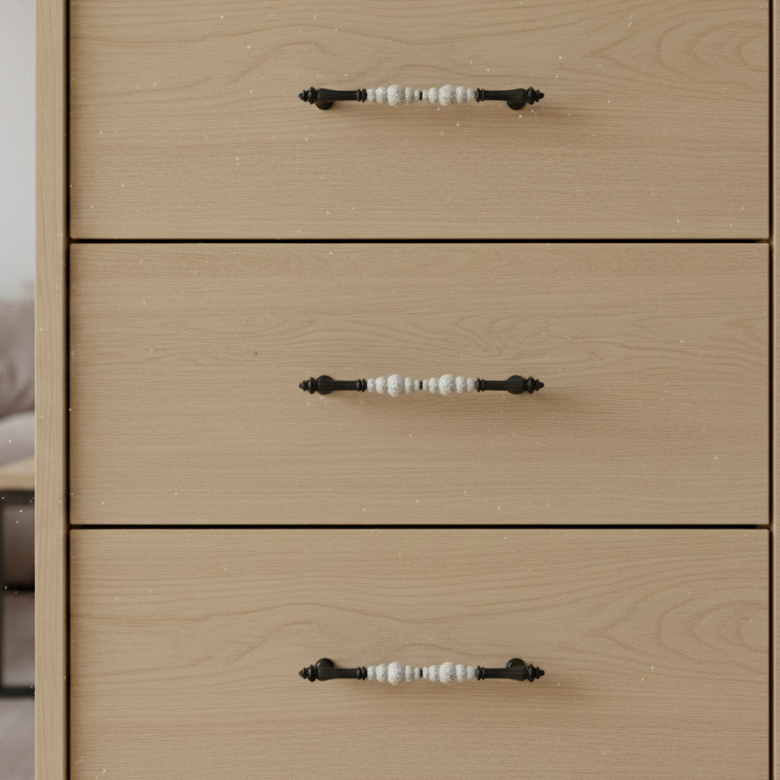 Wooden dresser with four drawers and black handles in a room setting.