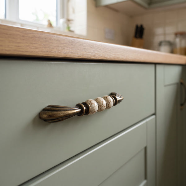 Florentine Bead Bar Handle in BROWN+AB, 128mm, fitted on a kitchen drawer